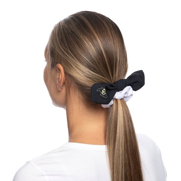 This is a plain white scrunchie with a black, detachable bow tied around it. Out of the box, the Buffalo log is on the right side.